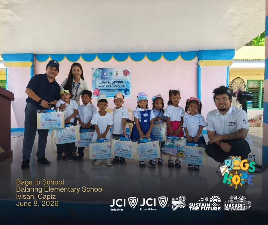 JCI Roxas Halaran members with pupils holding new school bags at Bags of Hope 2026